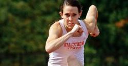 closeup of runner jumping over hurdle toward the camera