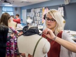 Fashion Design Student Applying fabric to mannequin