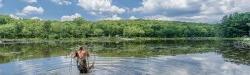 Student with a dragnet walking in lake.