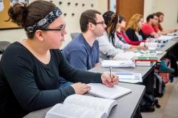 Student taking notes in class and following the lecture.