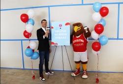 Rocky and a man standing in front of a sign that reads "Future Home of Saxbys"