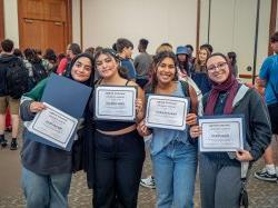 Four students hold certificates.