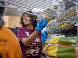 A Bonner Leader placing items on shelves at the food pantry of Saint Peter’s Haven, a nonprofit in Clifton dedicated to feeding the hungry 和 assisting the homeless.