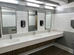 The bathroom in Stone Hall featuring three sinks and mirrors.