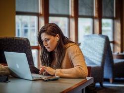 girl studying on a laptop in a building at Montclair State