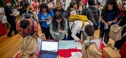 Image of a student shaking hands with a prospective employer at a campus career fair.