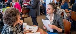 Picture of a student speaking with a prospective employer at a career fair.