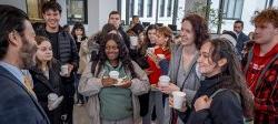 Picture of President Koppell chatting with students, enjoying snacks.