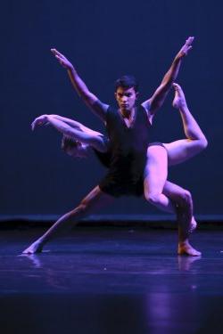 Photo of two dancers, one supporting the other.