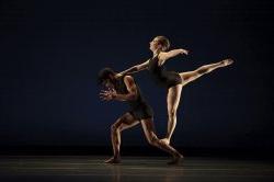 Photo of male and female dancers, one in a leaping pose.