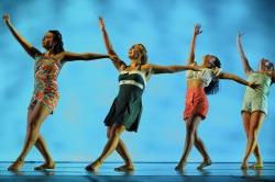 Photo of dancers with arms raised up