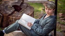 Natalya Kozlovski on outdoor steps with notepad